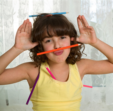 Little girl fooling around with colored pencils