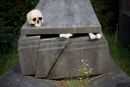 Halloween scene of broken bones and skull on a tombstoneの写真素材