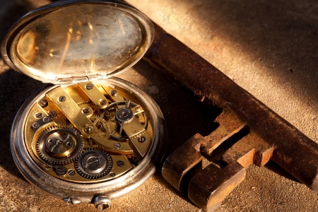 Rusty keys and an antique pocket watch on a grunge backgroundの写真素材