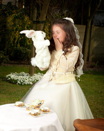 Alice in Wonderland girl drinking tea with a white rabbitのeditorial素材