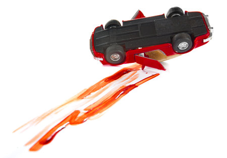 Blood marks and crashed toy car on a white backgroundの写真素材