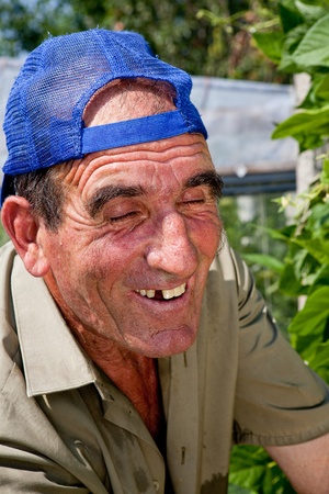 Closeup of an old bulgarian farmer smiling in his orchardの写真素材