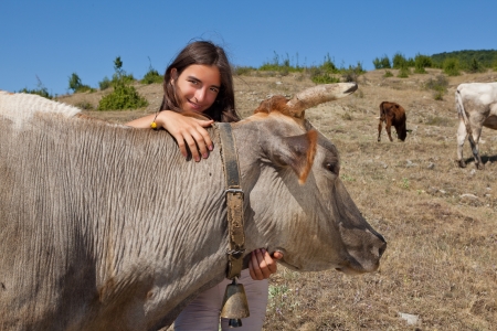 Young girl looking after the cows in the Bulgarian mountainsの写真素材