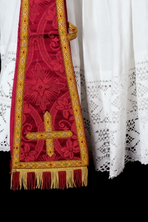 Antique red maniple hanging over the lace edge of an old priest surpliceの写真素材