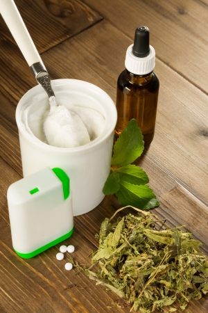 Powder stevia and liquid, dried and tablet forms on a wooden tableの写真素材