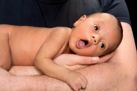 Biracial baby held by his caucasian father's armsの写真素材