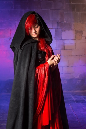 Gorgeous young vampire woman standing in a smokey medieval castleの写真素材