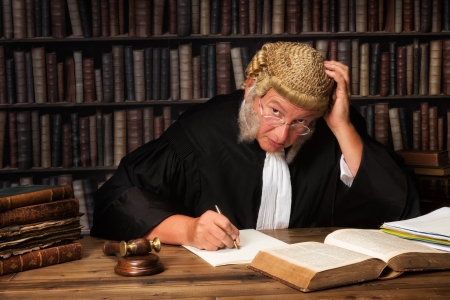 Mature judge with authentic court wig and gavel in courtの写真素材