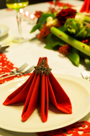 Christmas table decorated with red napkins and flower arrangementの写真素材