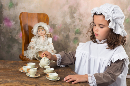Sweet victorian girl posing in the old style with an antique teapotの写真素材