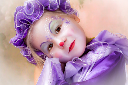 Beautiful little blond girl in clown disguiseの写真素材
