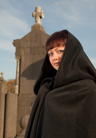 Lady with victorian cape visiting a very old graveyardの写真素材