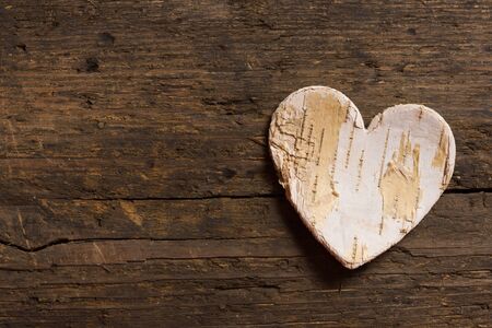 Hearts made of tree bark lying on a weathered old wooden textured tableの写真素材