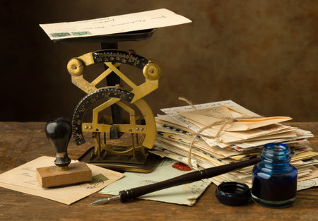 Antique letter scale on an old wooden table with a bundle of lettersの写真素材