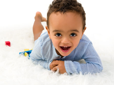 Young 18 month old toddler boy playing with wooden colorful blocks