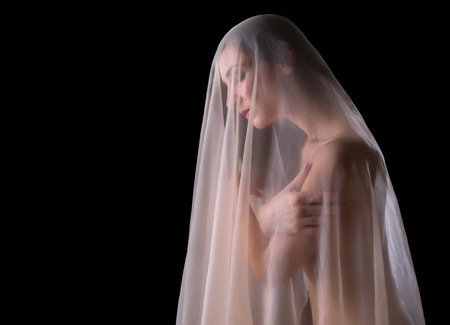 Implied nude image of a woman covered with a skintone chiffon veilの写真素材