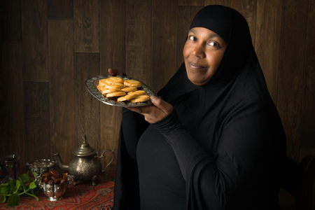Friendly African muslim woman presenting traditional cookiesの写真素材
