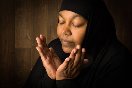 African muslim woman weiring a black veil in prayerの写真素材