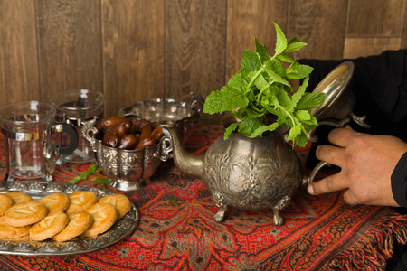 Hands of a muslim woman preparing mint tea the traditional wayの写真素材