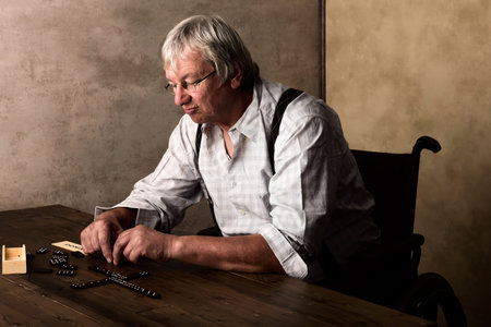 Old pensioner in nurshing home playing domino aloneの写真素材