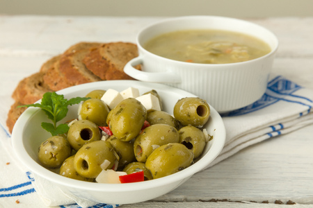 Grunge table board with soup, bread and olivesの写真素材