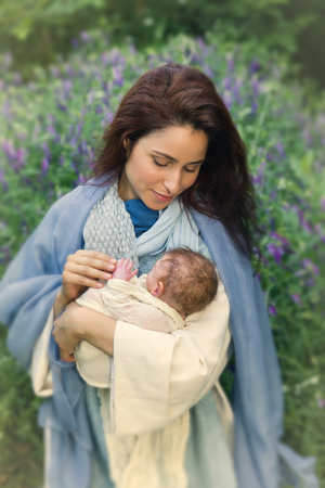 Virgin Mary holding baby Jesus in her arms - authentic play with realistic doll.の写真素材