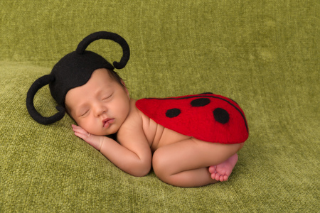 Adorable African newborn baby of 7 days old sleeping on a green blanketの写真素材