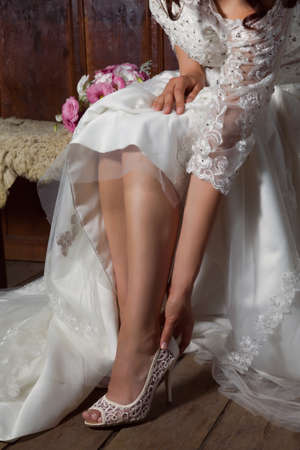 Stunning brunette bride putting her shoes onの写真素材