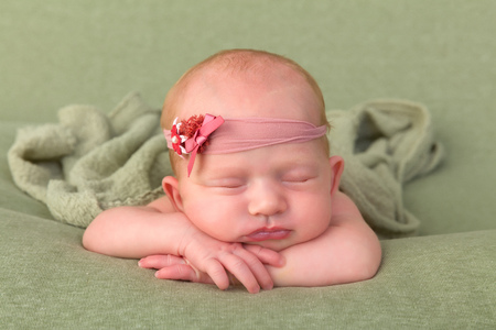 Cute newborn baby girl wearing a flower headbandの写真素材