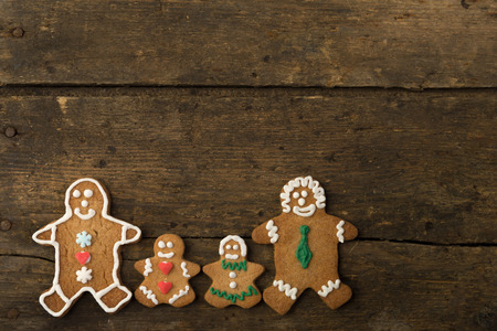 Gingerbread men family on a rustic wooden tableの写真素材