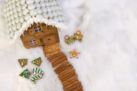 Cookie christmas tree and gingerbread house in a snow landscapeの写真素材
