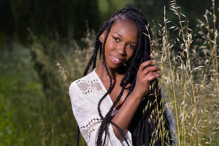 Beautiful young black woman enjoying nature in a high grass meadow