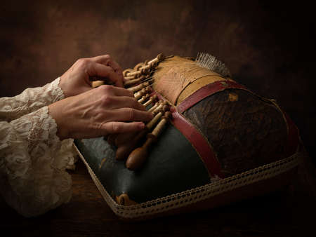 Hands of a woman working on an antique Flemish lace making pillowの写真素材