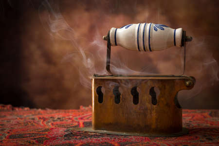 Antique victorian charcoal iron standing on vintage fabricの写真素材