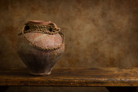 Still life of a rustic antique stoneware jug on a rustic old wooden shelf.の写真素材