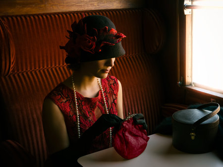 Attractive 1920s woman  in red flapper dress and cloche hat posing in the 1927 first class interior...