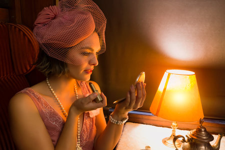 Reenactment scene of a 1920s flapper dress lady enjoying high tea in an authentic 1927 steam train...
