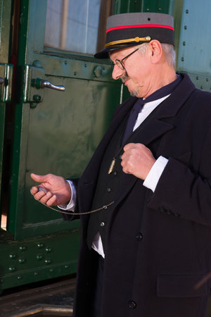 Reenactment scene of a vintage railway conductor at the departure of the first class train carriage