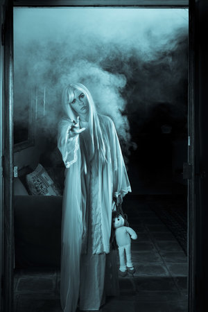 Female ghost wearing antique white nightgown wandering through an antique houseの写真素材