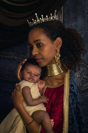 Reenactment scene of a live virgin Mary or Madonna posing with an African baby dollの写真素材