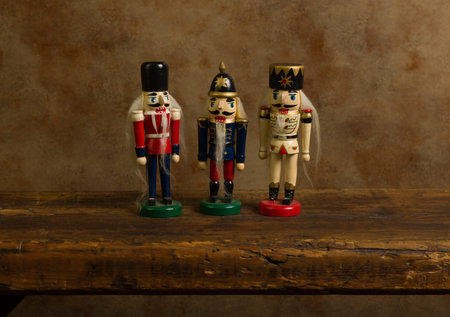 Funny nutcracker puppets trio standing on a rustic old wooden shelf.