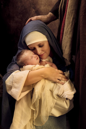 Mother playing Virgin Mary in a reenactment christmas nativity scene with her own 8 days old babyの写真素材