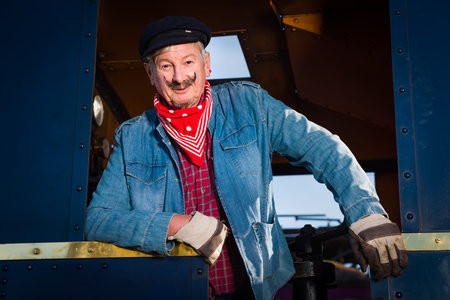 Reenactment scenes of a vintage worker or machinist in an authentic 1922 locomotive with restored engineの写真素材