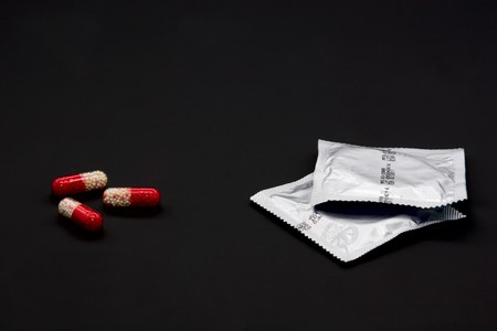 Safe : condoms and oral contraceptive isolated on blackの写真素材