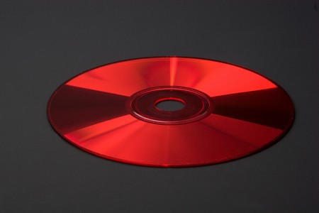 Shiny colored glares on red CD/DVD isolated on blackの写真素材