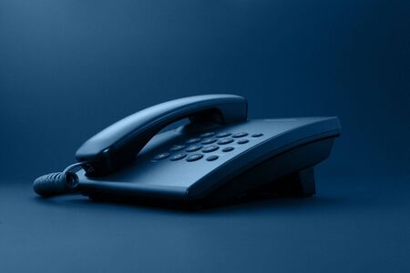 Black office phone with cord isolated on black under sepiaの写真素材