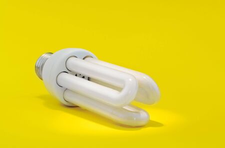 New energy: energy saving bulb under light spot on yellowの写真素材