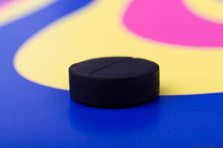 Hallucinogen: black pill macro over color background (focus on pill) の写真素材