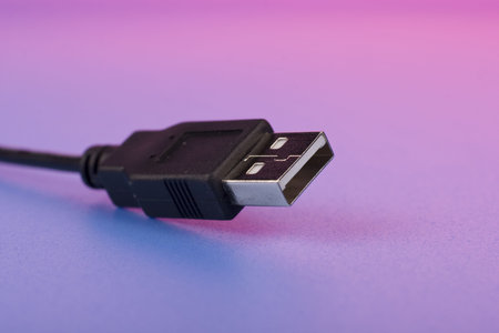 Black USB cord macro on color background