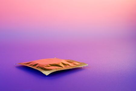 Yellow condom on color backgroundの写真素材